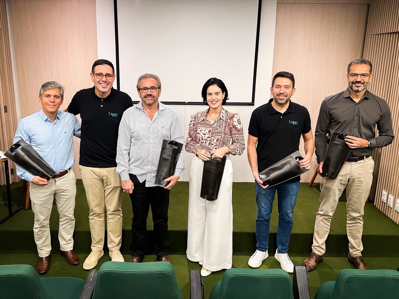 Participantes do Summit de Reconstrução Articular: Joelho em frente à tela de apresentação